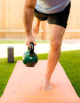 man-holding-kettle-ball-one-leg